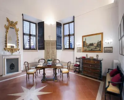 a living room with a table and chairs and a fireplace at Campitelli Fascinating Apartment in Rome