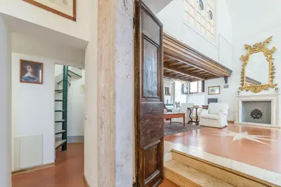 an open hallway with a wooden door and a living room at Campitelli Fascinating Apartment in Rome