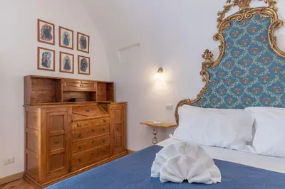 a bedroom with a large bed and a wooden dresser at Campitelli Fascinating Apartment in Rome