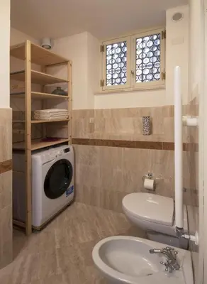 a bathroom with a toilet and a washing machine at Campitelli Fascinating Apartment in Rome