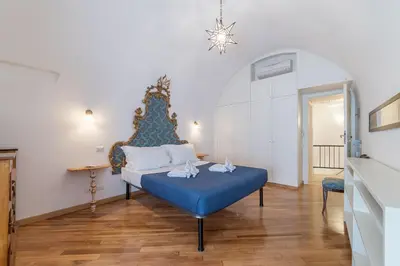 a bedroom with a blue bed in a room at Campitelli Fascinating Apartment in Rome