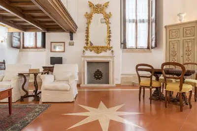 a living room with a table and chairs and a fireplace at Campitelli Fascinating Apartment in Rome