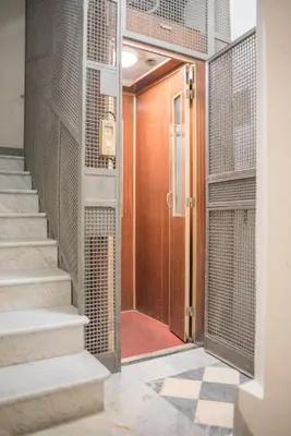 a hallway with a wooden door and stairs at Frattina De Luxe in Rome