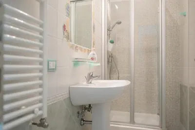 a white bathroom with a sink and a shower at Frattina De Luxe in Rome