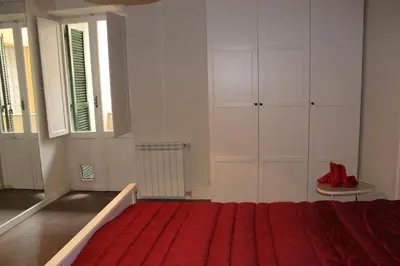 a bedroom with a red bed and white cabinets at Mama Trastevere in Rome