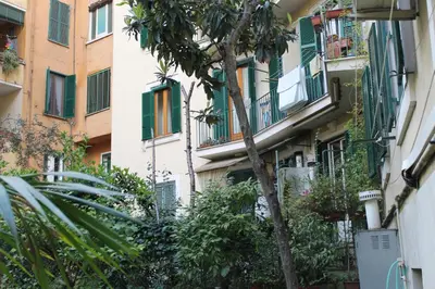 an apartment building with balconies and a tree at Mama Trastevere in Rome
