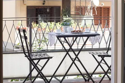 a table with a plate of food on a balcony at Gregory House in Rome