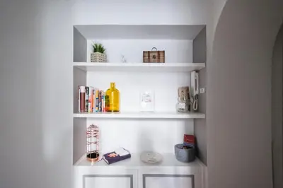 a white book shelf with books and other items at Apartment Near Trevi Fountain in Rome