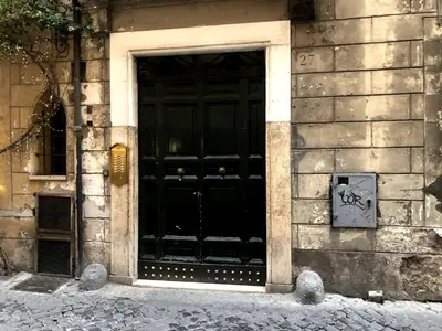 a black door on a building with graffiti on it at Apartment Near Trevi Fountain in Rome