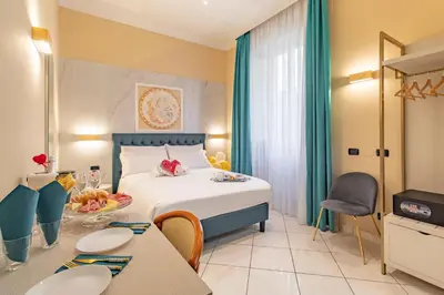 a hotel room with a bed and tables and chairs at Hotel Suite Caesar in Rome