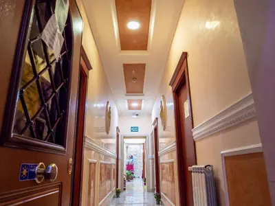 a hallway of a building with a door and a hallwayngth at Hotel Suite Caesar in Rome