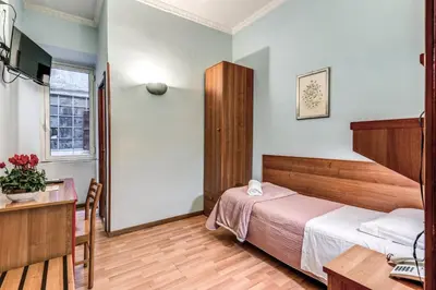 a hotel room with a bed and a desk and a table at Hotel Altavilla in Rome