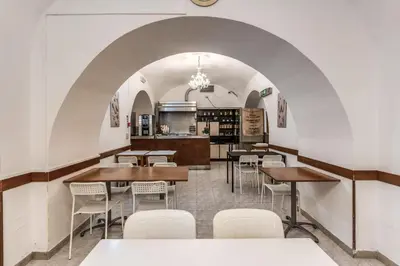 a restaurant with tables and chairs and a kitchen at Hotel Altavilla in Rome
