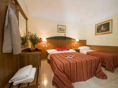 a hotel room with two beds with red sheets at Hotel Altavilla in Rome