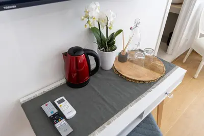 a table with a coffee maker and flowers on it at San Pietro Roma Suite in Rome