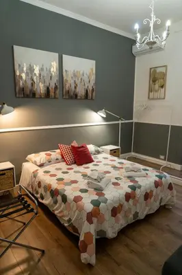 a bedroom with a bed and paintings on the wall at San Pietro Roma Suite in Rome