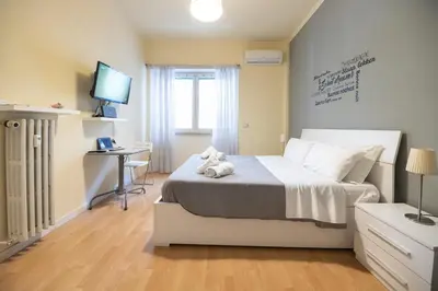 a bedroom with a bed with a desk and a television at Le Piazze di Roma Sweet Apartment in Rome