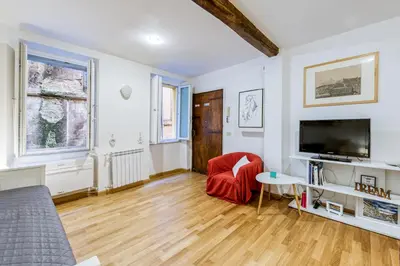 a living room with a television and a red chair at Deluxe Apartment - Campo dei Fiori in Rome