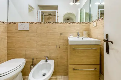 a bathroom with a sink and a toilet and a mirror at Deluxe Apartment - Campo dei Fiori in Rome