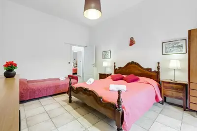 a bedroom with a large bed with pink sheets at Domus Ricca Termini in Rome