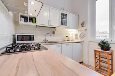a kitchen with white cabinets and a stove top oven at Domus Ricca Termini in Rome