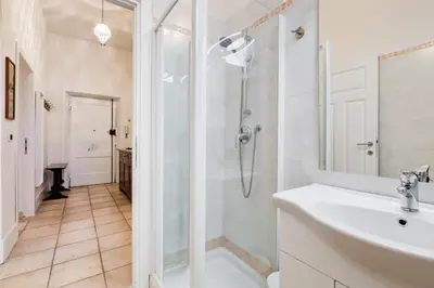 a white bathroom with a shower and a sink at Domus Ricca Termini in Rome