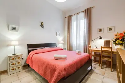 a bedroom with a red bed and a desk at Domus Ricca Termini in Rome
