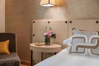 a bedroom with a bed and a vase of flowers on a table at Starhotels Metropole in Rome