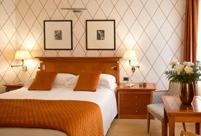 a hotel room with a bed and a chair at Starhotels Metropole in Rome