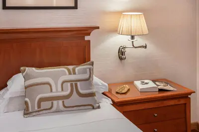 a bedroom with a bed with a lamp and a table at Starhotels Metropole in Rome