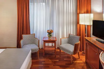 a hotel room with two chairs and a table with a television at Starhotels Metropole in Rome