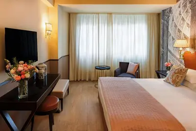 a hotel room with a bed and a desk and a room at Starhotels Michelangelo Rome in Rome