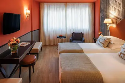 a hotel room with two beds and a television at Starhotels Michelangelo Rome in Rome