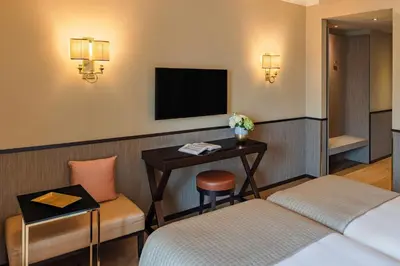 a hotel room with a bed and a desk and a television at Starhotels Michelangelo Rome in Rome