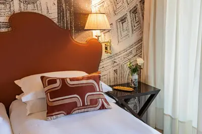 a bedroom with a bed and a table with a lamp at Starhotels Michelangelo Rome in Rome