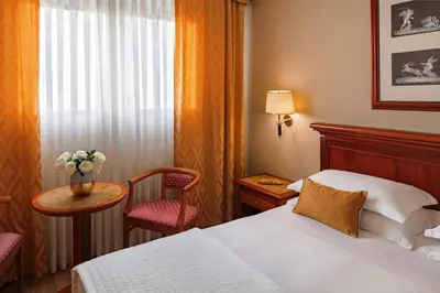 a hotel room with a bed and a table and a chair at Starhotels Michelangelo Rome in Rome