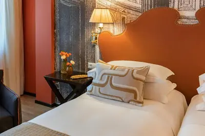 a bedroom with a white bed with a orange wall at Starhotels Michelangelo Rome in Rome