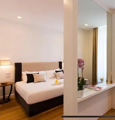 a bedroom with a bed and a table with flowers at 900 Piazza del Popolo in Rome