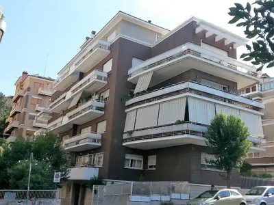 a building with balconies and cars parked in front of it at San Pietro & Trastevere Home in Rome