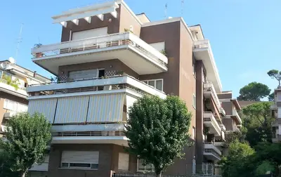 a tall building with balconies and trees in front of it at San Pietro & Trastevere Home in Rome