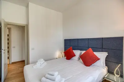 a bedroom with a large white bed with red pillows at Magia at Colosseum in Rome