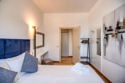a bedroom with a white bed with a blue headboard at Magia at Colosseum in Rome