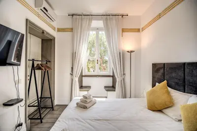 a bedroom with a large white bed with a window at Magia at Colosseum in Rome