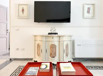 a living room with a tv on a wall at Modern Comfort, Poetic Charm in Rome
