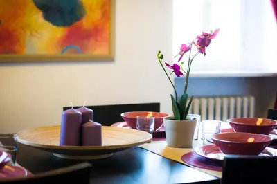 a table with candles and bowls and a vase with flowers at Lo Chalet di Trastevere in Rome