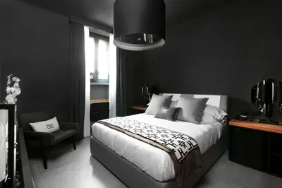 a black bedroom with a bed and a chair at Parioli Place B&B in Rome