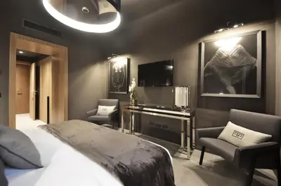 a bedroom with a bed and two chairs and a television at Parioli Place B&B in Rome