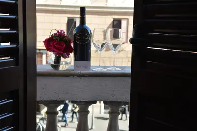 a bottle of wine and two wine glasses on a counter at Room 91-S. Peter in Rome