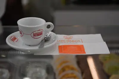 a cup of coffee sitting on a plate next to a pastry at Room 91-S. Peter in Rome