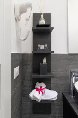 a bathroom with a shelf with towels and a phone at Room 91-S. Peter in Rome